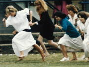 FILE - In this file photo dated Tuesday, June 28, 1989, Britain's Princess Diana wearing a white dress, races ahead during the mother's race, held during a sports day for Wetherby school, where her son Prince William is a pupil. T For someone who began her life in the spotlight as "Shy Di," Princess Diana became an unlikely, revolutionary during her years in the House of Windsor. She helped modernize the monarchy by making it more personal, changing the way the royal family related to people. By interacting more intimately with the public -- kneeling to the level of children, sitting on edge of a patient's hospital bed, writing personal notes to her fans -- she set an example that has been followed by other royals as the monarchy worked to become more human and remain relevant in the 21st century.