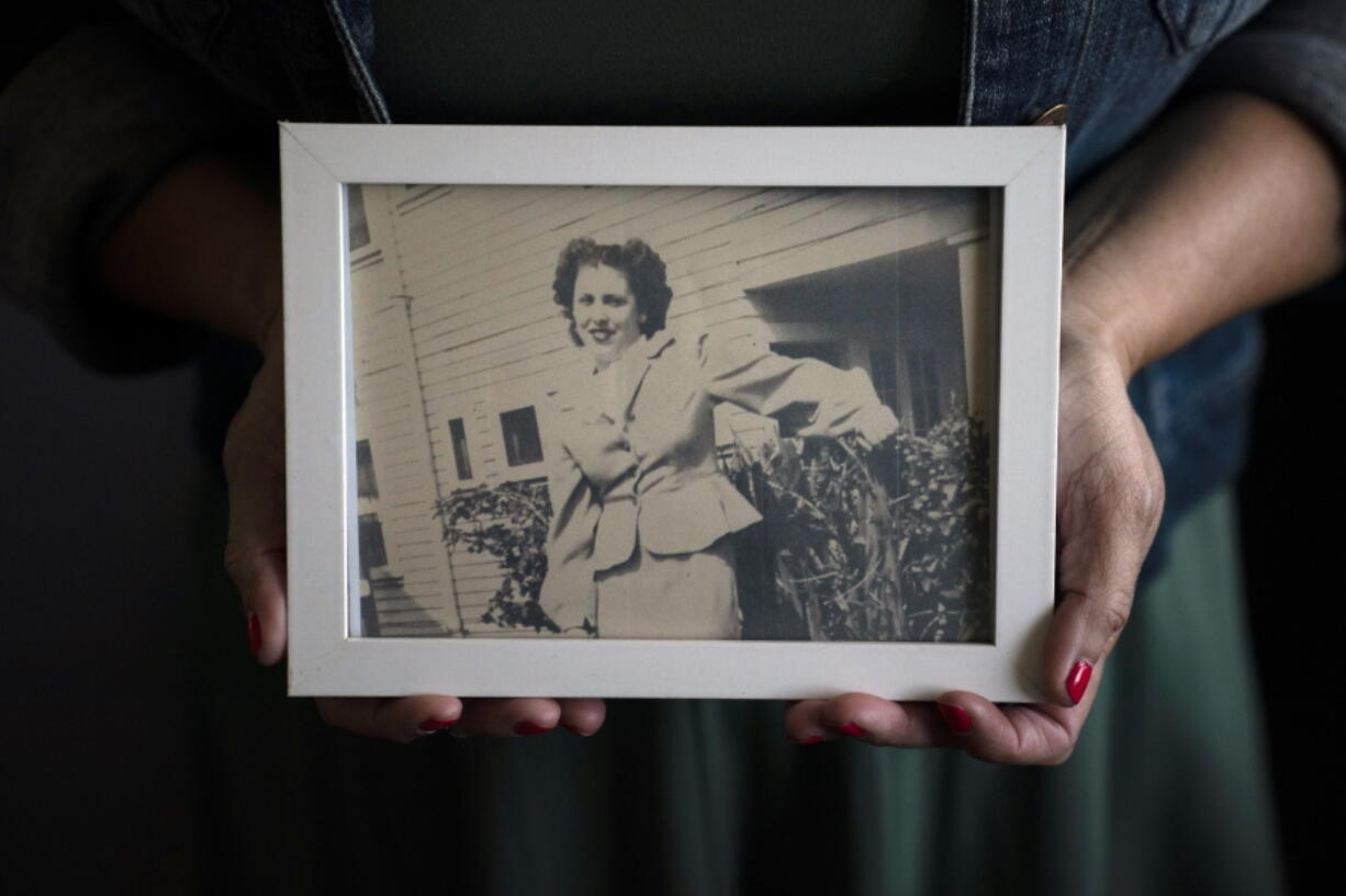 Stacy Cordova, whose aunt was a victim of California's forced sterilization program that began in 1909, holds a framed photo of her aunt Mary Franco, Monday, July 5, 2021, in Azusa, Calif. Franco was sterilized when she was 13 in 1934. Franco has since died, but Cordova has been advocating for reparations on her behalf. (AP Photo/Jae C.