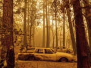 Following the Dixie Fire, scorched cars are seen in a clearing in the Indian Falls community of Plumas County, Calif., on Sunday, July 25, 2021.