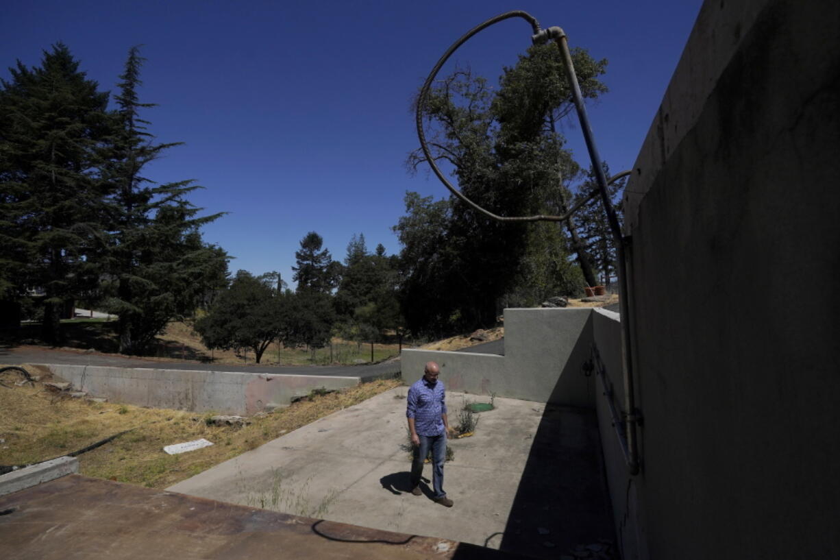 Will Abrams walks on the lot of his family home that was destroyed by wildfires in 2017 while interviewed in Santa Rosa, Calif., Thursday, June 24, 2021. Pacific Gas & Electric's CEO is pledging that the future will get "easier" and "brighter." But those words are ringing hollow one year after PG&E emerged from a complex bankruptcy triggered by a succession of harrowing wildfires ignited by its long-neglected electrical grid.