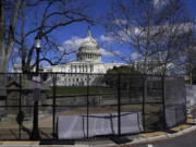 The U.S. Capitol is seen behind security fencing on April 2 in Washington. The fencing was installed after the  Jan. 6 insurrection.