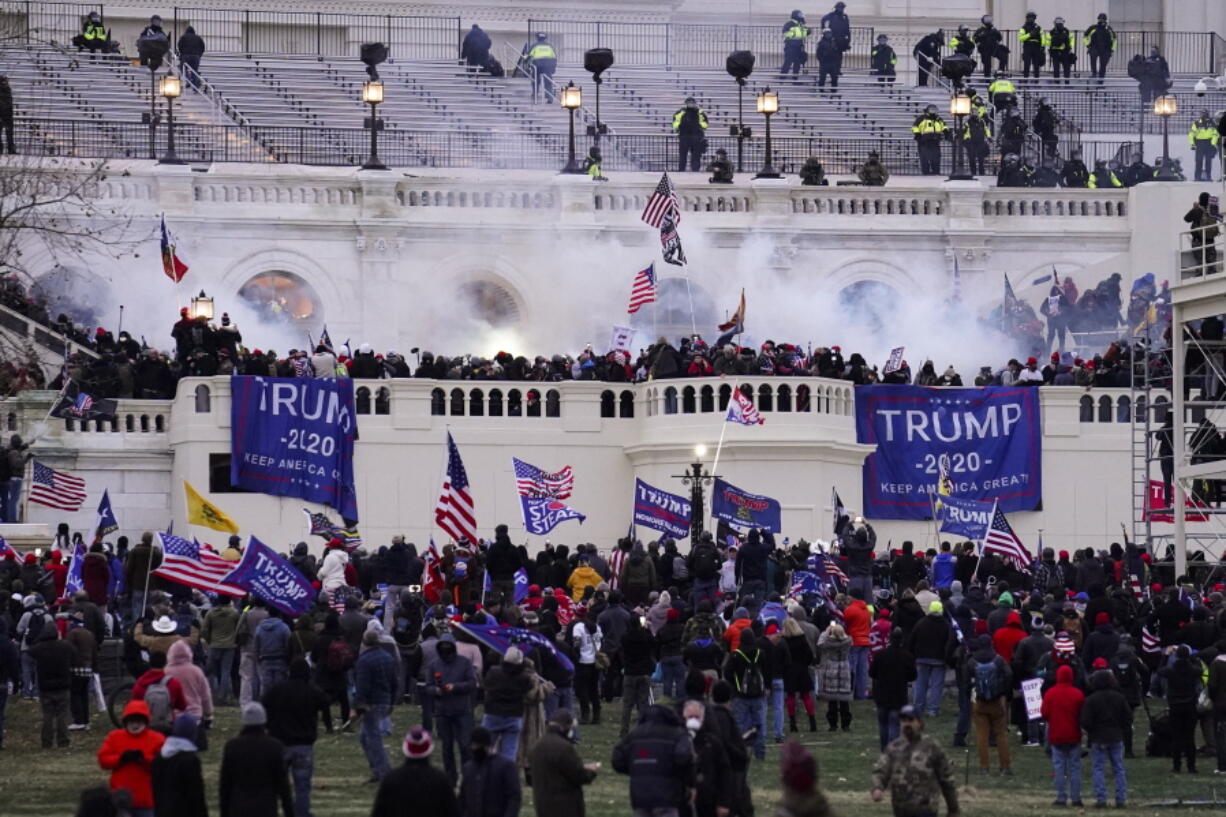 FILE - In this Jan. 6, 2021, file photo, violent protesters, loyal to then-President Donald Trump, storm the Capitol, Wednesday, Jan. 6, 2021, in Washington. Two Seattle police officers who were in Washington, D.C., during the January 6 insurrection were illegally trespassing on Capitol grounds while rioters stormed the building, but lied about their actions, a police watchdog said in a report released Thursday, July 8, 2021.