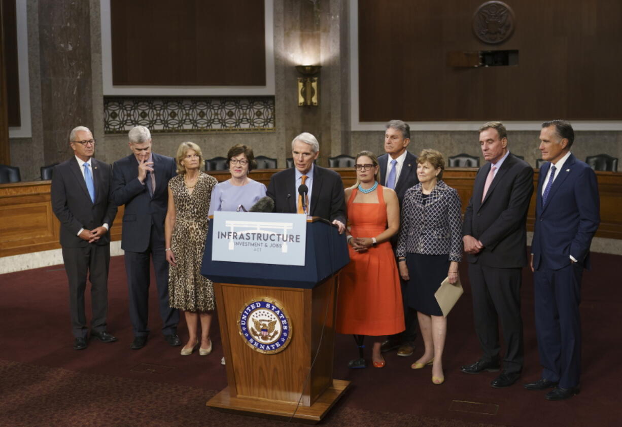 The bipartisan group of Senate negotiators speak to reporters just after a vote to start work on a nearly $1 trillion bipartisan infrastructure package, at the Capitol in Washington, Wednesday, July 28, 2021. From left are Rep. Kevin Cramer, R-N.D., Sen. Bill Cassidy, R-La., Sen. Lisa Murkowski, R-Alaska, Sen. Susan Collins, R-Maine, Sen. Rob Portman, R-Ohio, Sen. Kyrsten Sinema, D-Ariz., Sen. Joe Manchin, D-W.Va., Sen. Jeanne Shaheen, D-N.H., Sen. Mark Warner, D-Va., and Sen. Mitt Romney, R-Utah. (AP Photo/J.