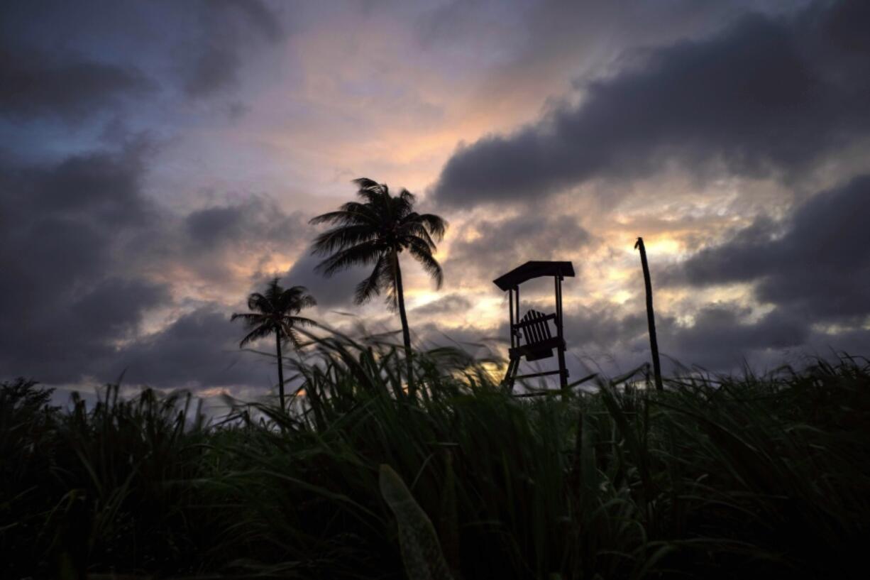 Wind moves the grass and palm trees under a cloudy sky after the passage of Tropical Storm Elsa in Havana, Cuba, Monday, July 5, 2021.