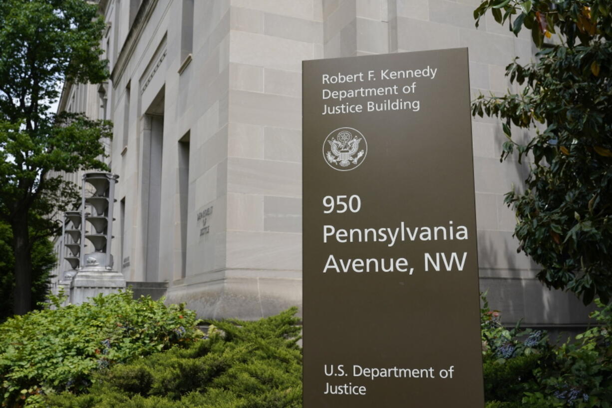 FILE - This May 4, 2021 file photo shows a sign outside the Robert F. Kennedy Department of Justice building in Washington. The Russian hackers behind the massive SolarWinds cyberespionage campaign broke into the email accounts some of the most prominent federal prosecutors' offices around the country last year, the Department of Justice said Friday, July 30, 2021.