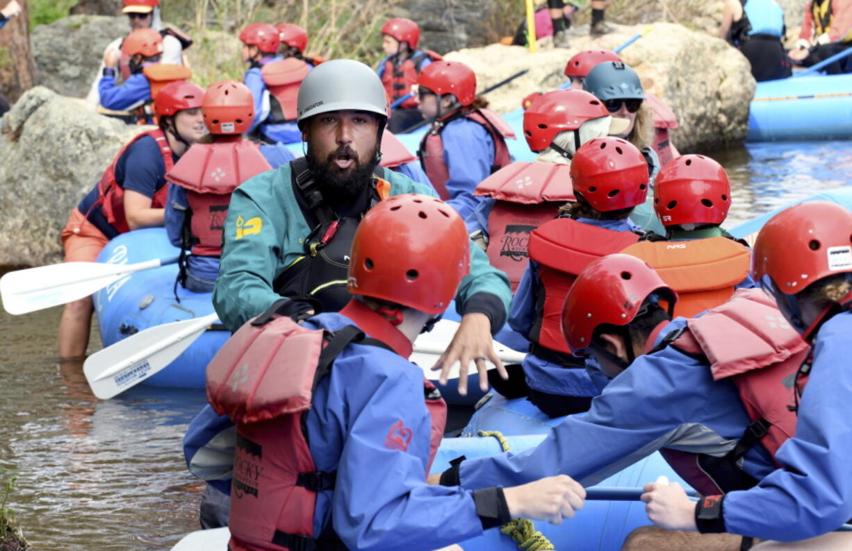 Kyle Lester, a rafting guide for Rocky Mountain Adventures, teaches a group basic safety measures and rowing techniques before floating down the Cache la Poudre River near Fort Collins, Colo., Wednesday, June 23, 2021. The river in northern Colorado is flowing well compared to waterways in the western part of the state, much of which is experiencing extreme drought.