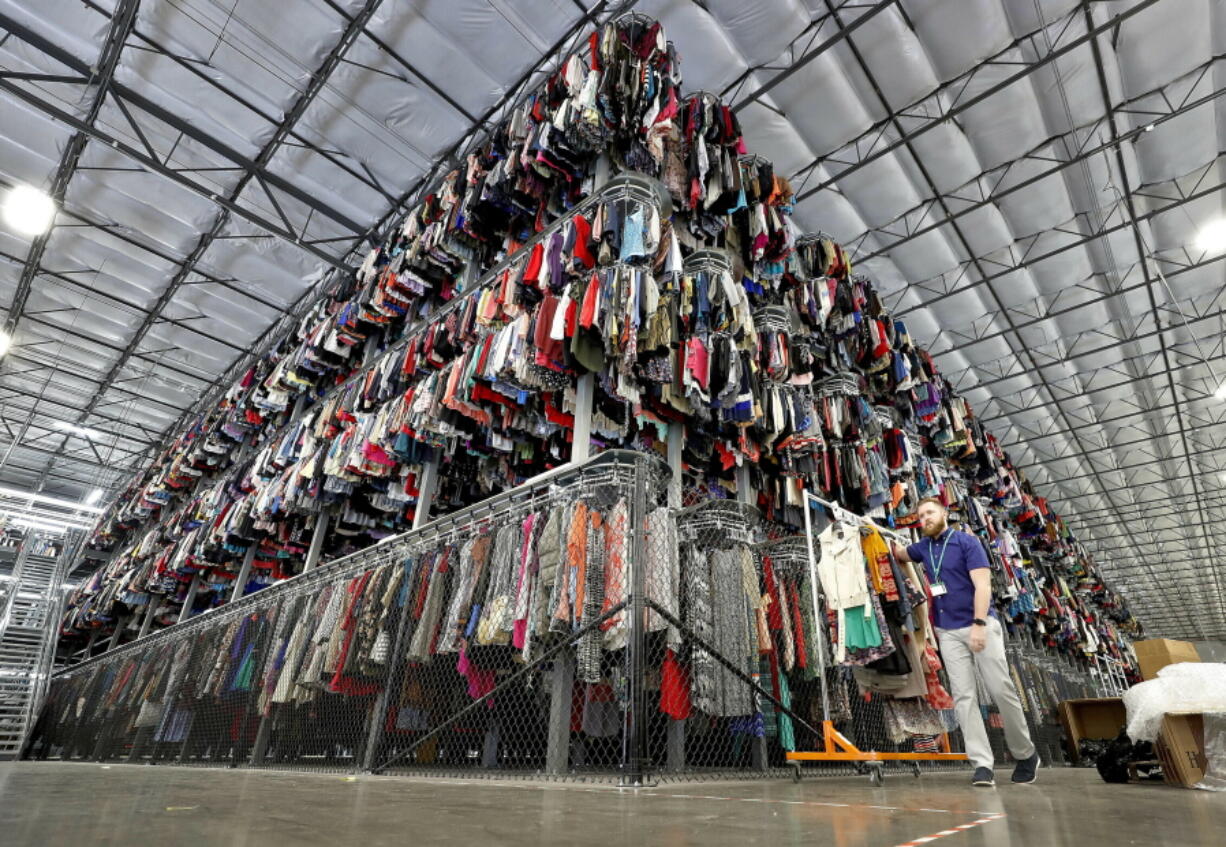 FILE - Thousands of garments are stored on a three-tiered conveyor system at the ThredUp sorting facility in Phoenix on March 12, 2019. A wardrobe purge is on for some as vaccinations have taken hold, restrictions have lifted and offices reopen or finalize plans to do so. The primary beneficiaries are secondhand clothing marketplaces, and brick-and-mortar donation spots.