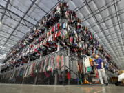 FILE - Thousands of garments are stored on a three-tiered conveyor system at the ThredUp sorting facility in Phoenix on March 12, 2019. A wardrobe purge is on for some as vaccinations have taken hold, restrictions have lifted and offices reopen or finalize plans to do so. The primary beneficiaries are secondhand clothing marketplaces, and brick-and-mortar donation spots.