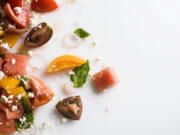 This image released by Milk Street shows a recipe for watermelon salad with tomato, basil and goat cheese.