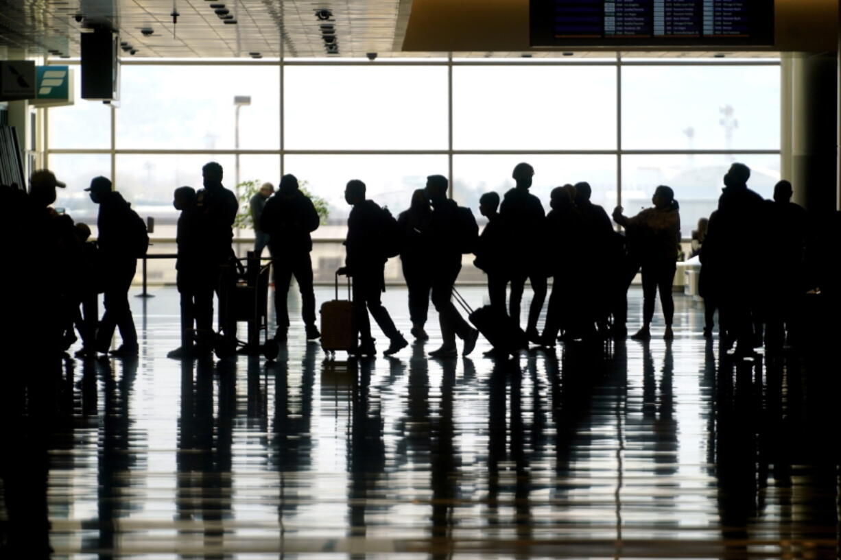 FILE - In this Wednesday, March 17, 2021 file photo, travelers walk through the Salt Lake City International Airport in Salt Lake City. Of the 2 million people clogging airport security lines and gate areas again each day, one crowd is still largely missing: business travelers. Their absence is noteworthy because they are a key source of revenue and profit, underpinning a record-breaking stretch of financial gain for U.S. airlines that ended with the coronavirus. Business travelers tend to pay higher fares, and that is especially true on international flights, which are also still deeply depressed by the pandemic and travel restrictions around the globe.