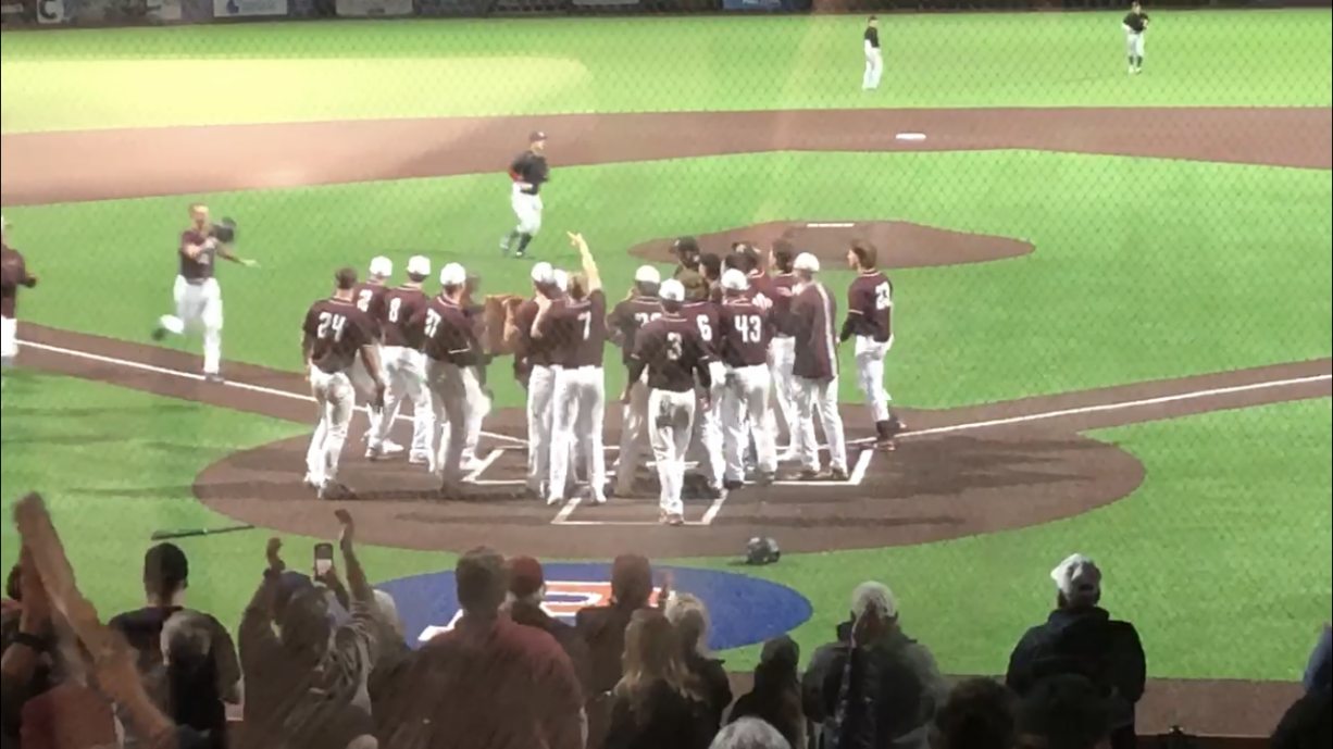 The Ridgefield Raptors await Kody Darcy at home plate after his three-run homer gave Ridgefield a 8-5 win over the Bellingham Bells in 10 innings on Thursday in Ridgefield.