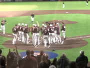 The Ridgefield Raptors await Kody Darcy at home plate after his three-run homer gave Ridgefield a 8-5 win over the Bellingham Bells in 10 innings on Thursday in Ridgefield.