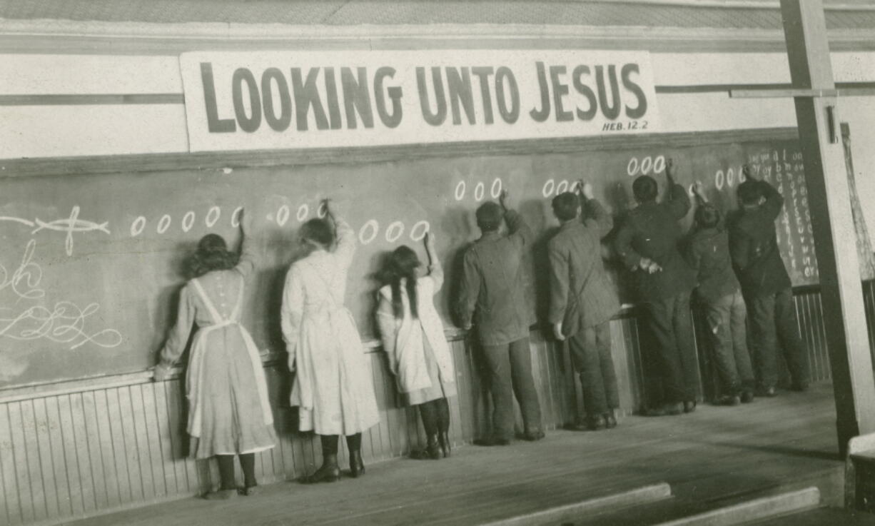 Students write on a chalkboard in the 1910s at the Red Deer Indian Industrial School in Alberta. In Canada, where more than 150,000 Indigenous children attended residential schools over more than a century, a National Truth and Reconciliation Commission identified 3,201 deaths amid poor conditions.