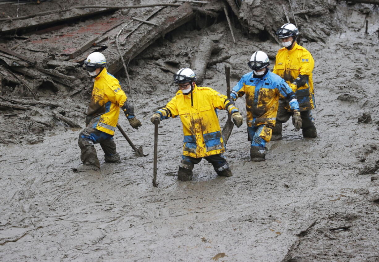 Rescuers conduct a search operation at the site of a mudslide at Izusan in Atami, Shizuoka prefecture, southwest of Tokyo, Sunday, July 4, 2021. More than 1,000 soldiers, firefighters and police on Sunday waded through a giant mudslide that ripped through the resort town as it swept away houses and cars.