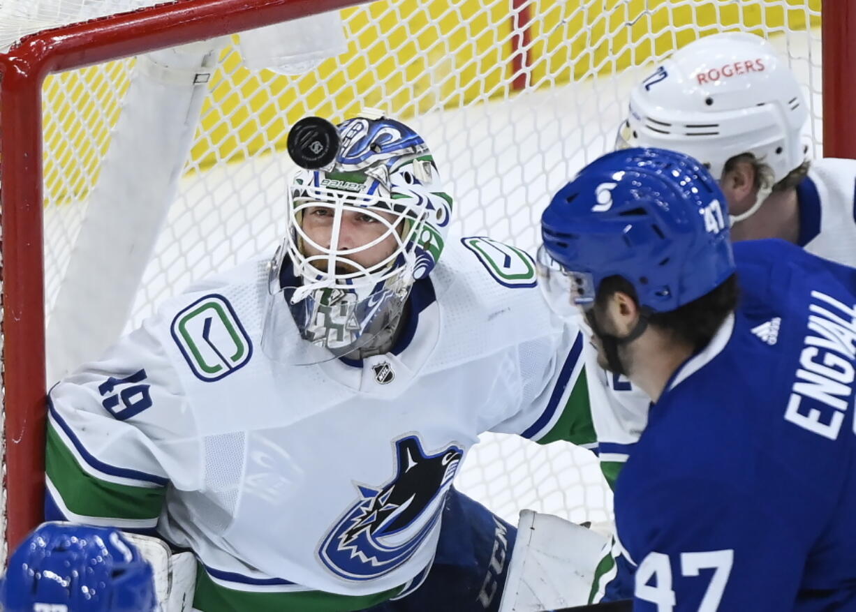 FILE - Vancouver Canucks goaltender Braden Holtby (49) eyes the loose puck during the first period of an NHL hockey game against the Toronto Maple Leafs in Toronto, in this Thursday, April 29, 2021, file photo. At right is Toronto forward Pierre Engvall (47). Carey Price's questionable injury status clouds the Seattle Kraken's selection process in their expansion draft. The Montreal Canadiens goaltender with connections to the Pacific Northwest could become the cornerstone and face of the franchise if picked. Stanley Cup champion and 2016 Vezina Trophy winner Braden Holtby would also fit that bill.