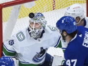 FILE - Vancouver Canucks goaltender Braden Holtby (49) eyes the loose puck during the first period of an NHL hockey game against the Toronto Maple Leafs in Toronto, in this Thursday, April 29, 2021, file photo. At right is Toronto forward Pierre Engvall (47). Carey Price's questionable injury status clouds the Seattle Kraken's selection process in their expansion draft. The Montreal Canadiens goaltender with connections to the Pacific Northwest could become the cornerstone and face of the franchise if picked. Stanley Cup champion and 2016 Vezina Trophy winner Braden Holtby would also fit that bill.