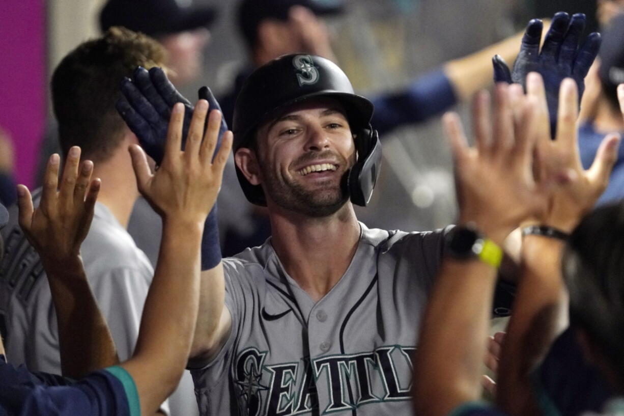 Seattle Mariners' Mitch Haniger is congratulated by teammates after hitting a two-run home run during the seventh inning of a baseball game against the Los Angeles Angels Friday, July 16, 2021, in Anaheim, Calif. (AP Photo/Mark J.