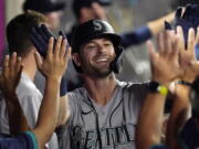 Seattle Mariners' Mitch Haniger is congratulated by teammates after hitting a two-run home run during the seventh inning of a baseball game against the Los Angeles Angels Friday, July 16, 2021, in Anaheim, Calif. (AP Photo/Mark J.