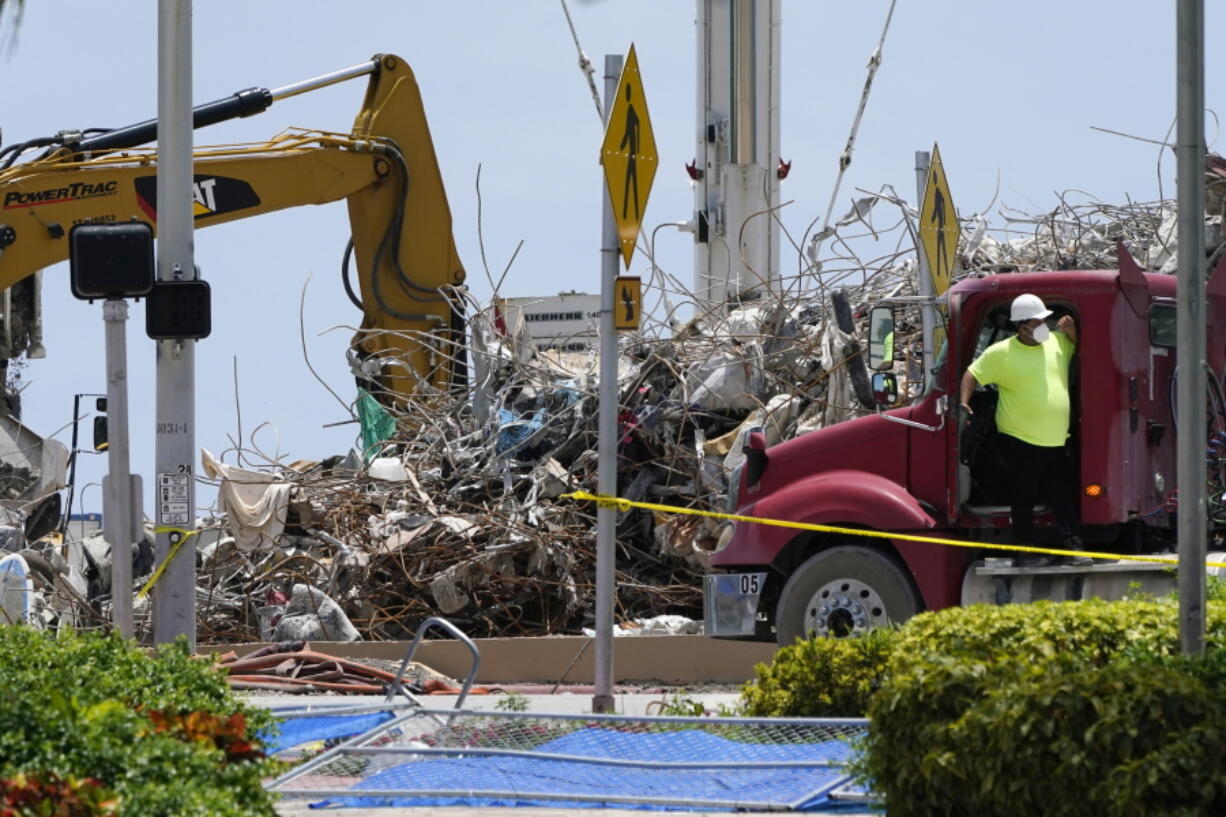 A worker waits to load his truck with debris from the rubble of the Champlain Towers South building, as removal and recovery work continues at the site of the partially collapsed condo building, Wednesday, July 14, 2021, in Surfside, Fla.