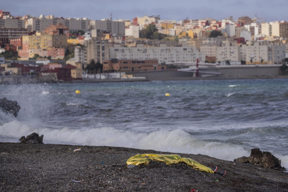 FILE - In this Thursday, May 20, 2021 file photo, the body of a young man covered with an emergency blanket after being recovered by Spanish police from waters near the border between Morocco and Spain's north African enclave of Ceuta. The U.N. migration agency says the number of migrants and refugees who died while attempting to reach Europe on dangerous sea routes more than doubled so far this year compared to the first six months of 2020. The International Organization for Migration said in a new report Wednesday, July 14, 2021 that at least 1,146 people perished between January and June.