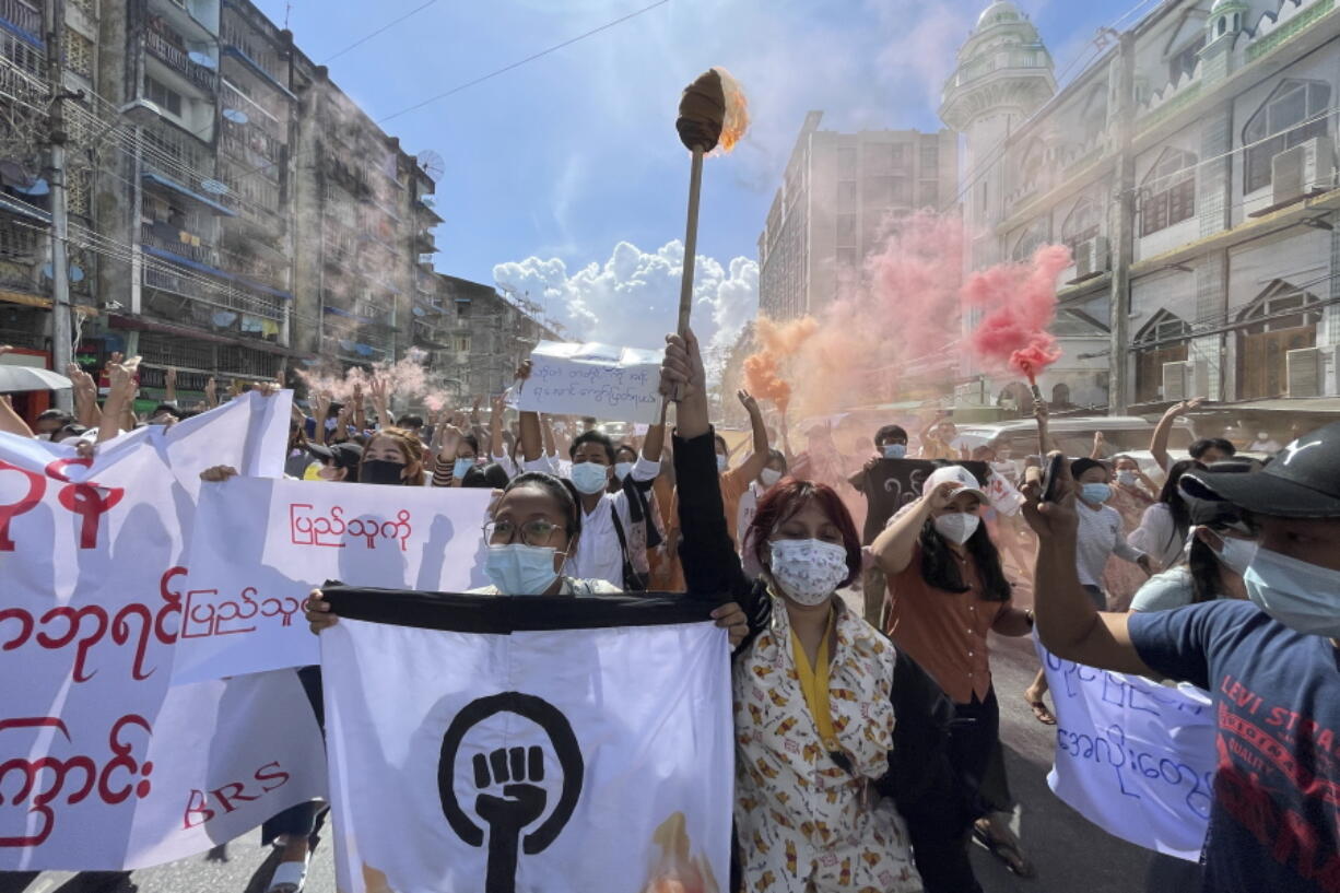 Protesters march holding slogans during a protest at Pazundaung township in Yangon, Myanmar, Wednesday July 14, 2021.