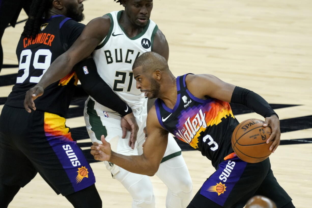 Phoenix Suns guard Chris Paul (3) drives pst Milwaukee Bucks guard Jrue Holiday (21) during the second half of Game 1 of basketball's NBA Finals, Tuesday, July 6, 2021, in Phoenix. (AP Photo/Matt York) (Ross D.