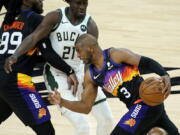 Phoenix Suns guard Chris Paul (3) drives pst Milwaukee Bucks guard Jrue Holiday (21) during the second half of Game 1 of basketball's NBA Finals, Tuesday, July 6, 2021, in Phoenix. (AP Photo/Matt York) (Ross D.