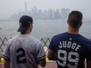 Staten Island Ferry commuters take in the view of lower Manhattan seen through haze, Tuesday, July 20, 2021, in New York. Smoke from wildfires across the U.S. West, including Oregon's Bootleg Fire, has wafted over large swaths of the eastern United States. David Lawrence, a meteorologist with the National Weather Service, said the skies could be hazy for the next couple weeks.