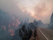 In this photo provided by the Oregon Department of Transportation flames from the Jack Fire burn along Oregon 138 near Steamboat, about 40 miles east of Roseburg, Oregon July 7, 2021. A 14-mile stretch of North Umpqua Highway is closed between Steamboat and Slide Creek due to the Jack Fire, that began Monday, July 5.