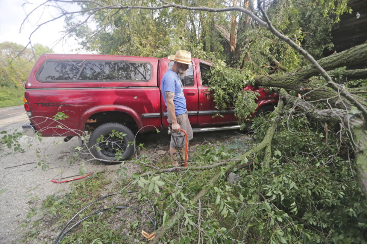 Adam Turley surveys the damage to his dad's truck in front of their home on Concord Center Drive in the Town of Concord, Wis., on Thursday, July 29, 2021. A line of thunderstorms arrived early Thursday generating numerous tornado warnings as well as high winds and near-constant lightning.