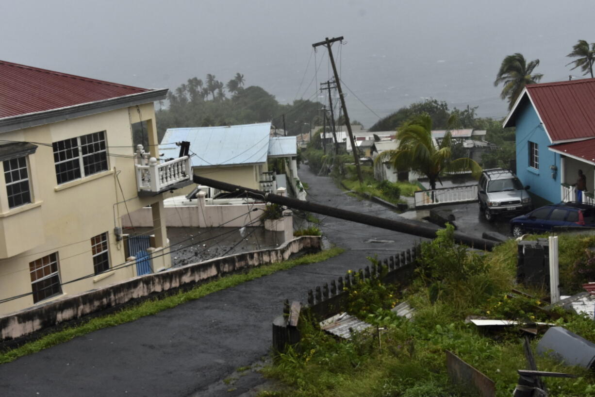 A utility pole felled by Hurricane Elsa leans on the edge of a residential balcony Friday in Cedars, St. Vincent.