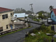 A utility pole felled by Hurricane Elsa leans on the edge of a residential balcony Friday in Cedars, St. Vincent.