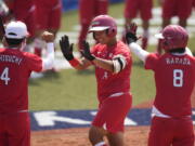 Japan's Minori Naito, center, celebrates with her teammates after hitting a two run home run during the softball game between Japan and Australia at the 2020 Summer Olympics, Wednesday, July 21, 2021, in Fukushima, Japan. (AP Photo/Jae C.