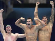 United States men's 4x100m freestyle relay team Bowen Beck, Blake Pieroni, and Caeleb Dressel celebrate after winning the gold medal at the 2020 Summer Olympics, Monday, July 26, 2021, in Tokyo, Japan.