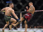 Dustin Poirier, right, kicks Conor McGregor during a UFC 264 lightweight mixed martial arts bout Saturday, July 10, 2021, in Las Vegas.