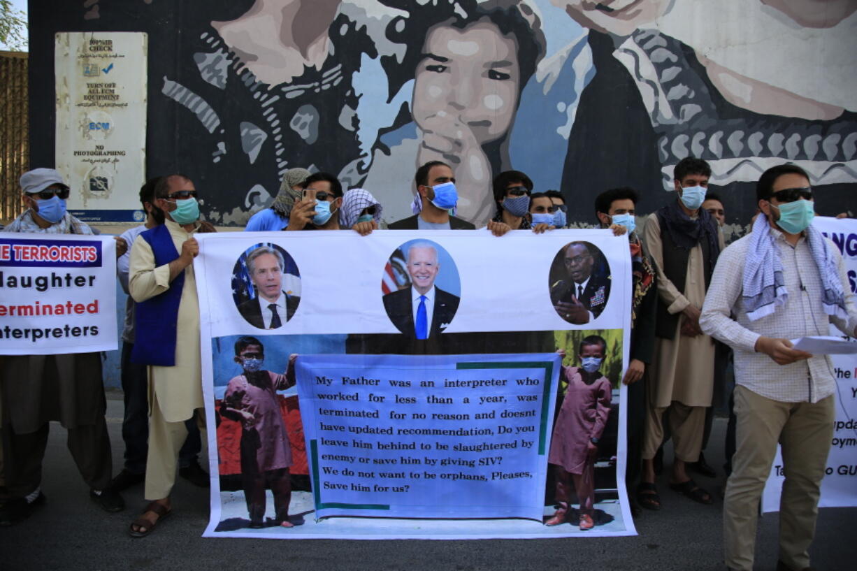 In this June 25, 2021 photo, Former Afghan interpreters hold placards during a demonstrations against the US government, in front of the US Embassy in Kabul, Afghanistan. The Biden administration says it will evacuate about 2,500 Afghans who worked for the U.S. government and their families to a military base in Virginia pending approval of their visas. The administration notified Congress on Monday that the Afghans will be housed at the Fort Lee Army base south of Richmond starting next week.