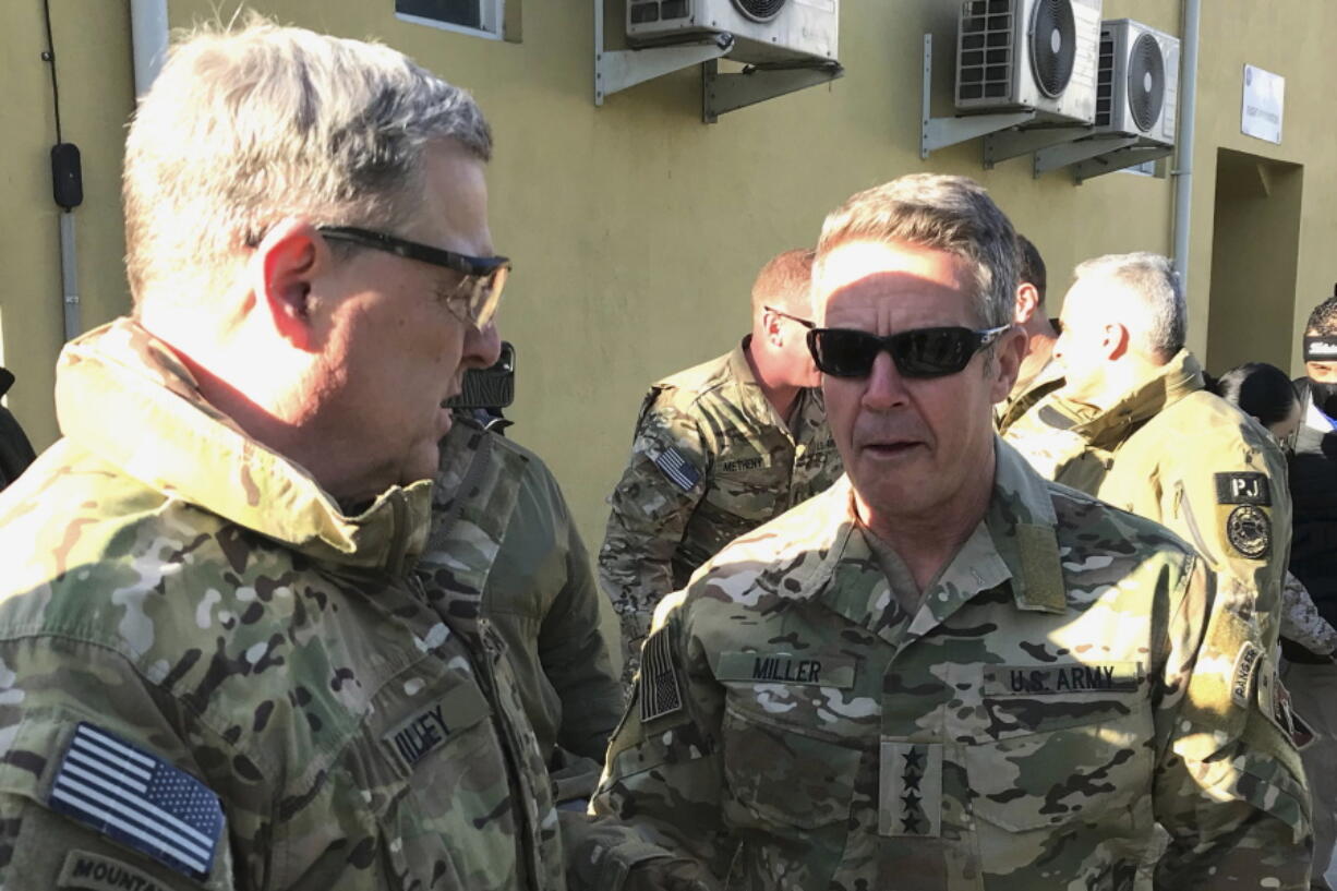 FILE - In this Dec. 16, 2020, file photo Chairman of the U.S. Joint Chiefs of Staff Gen. Mark Milley, left, talks with Gen. Scott Miller, the commander of U.S. and coalition forces in Afghanistan at Miller's military headquarters in Kabul, Afghanistan. The U.S. military will remain involved in the Afghanistan war into September, keeping the option of launching airstrikes against the Taliban to defend Afghan forces, U.S. officials said Thursday, July 1. For weeks, officials have said the withdrawal of the main U.S. military force and its equipment from Afghanistan would be largely completed by this weekend. Miller, the top U.S. commander there, would then leave, marking a significant turning point in the U.S. mission.