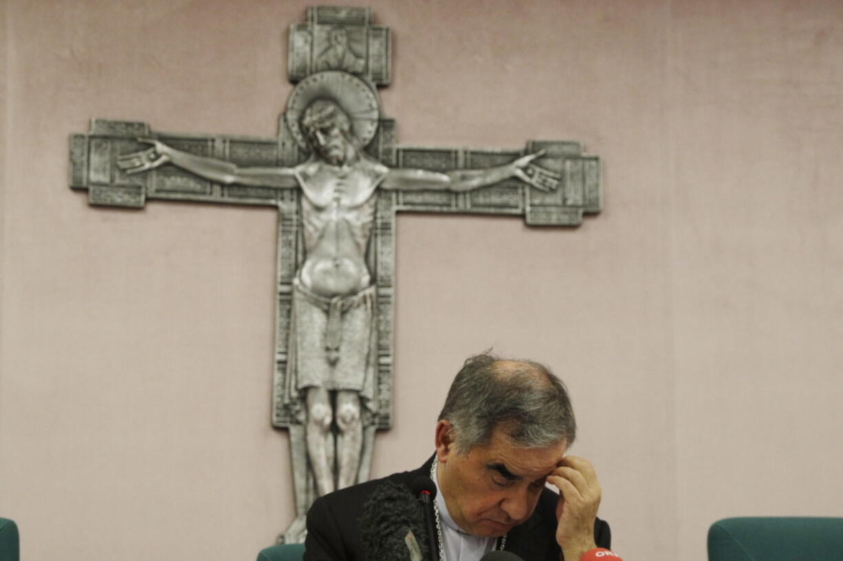 FILE - In this Friday, Sept. 25, 2020 file photo, Cardinal Angelo Becciu looks down as he meets the media during a press conference in Rome. The Vatican's criminal tribunal on Saturday, July 3, 2021 indicted 10 people, including a cardinal, and four companies on charges including extortion, abuse of office and fraud in connection with the Secretariat of State's 350 million-euro investment in a London real estate venture. Also indicted was another once-powerful Holy See official, Cardinal Angelo Becciu, who helped engineer the initial London investment when he was the chief of staff in the Secretariat of State.