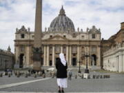 FILE - In this Sunday, March 21, 2021 filer, a nun stands in St. Peter's Square at the Vatican. Vatican prosecutors have alleged a jaw-dropping series of scandals in launching the biggest criminal trial in the Vatican's modern history, which opens Tuesday in a modified courtroom in the Vatican Museums. The once-powerful cardinal and nine other people are accused of bleeding the Holy See of tens of millions of dollars in donations through bad investments, deals with shady money managers and apparent favors to friends and family.