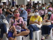 Residents wait to receives shots of the AstraZeneca COVID-19 vaccine at the Central Vaccination Center in Bangkok, Thailand, Thursday, July 15, 2021. As many Asian countries battle against a new surge of coronavirus infections, for many their first, the slow-flow of vaccine doses from around the world is finally picking up speed, giving hope that low inoculation rates can increase rapidly and help blunt the effect of the rapidly-spreading delta variant.