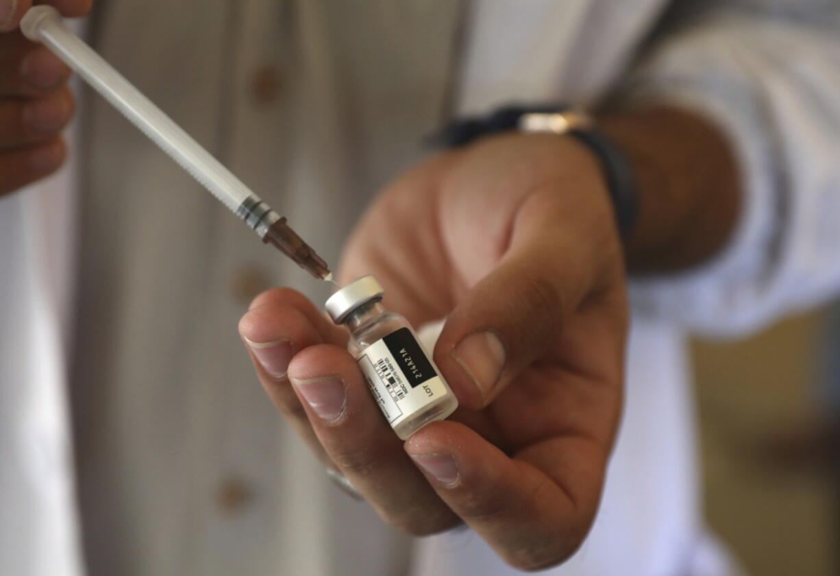 FILE - In this Sunday, July 11, 2021 file photo, a doctor fills a syringe with the Johnson & Johnson COVID-19 vaccine at a vaccination center in Kabul, Afghanistan. Top officials at the World Health Organization said Monday, July 12 there is not enough evidence to show that third doses of coronavirus vaccines are needed and appealed for the scarce shots to be shared with poor countries who have yet to immunize their populations instead of being used by rich countries as boosters.