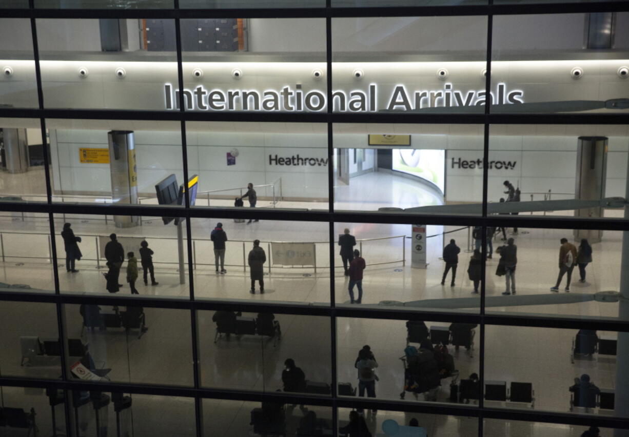 FILE - In this file photo dated Tuesday, Jan. 26, 2021, people in the International Arrivals area at Heathrow Airport in London, during England's coronavirus lockdown.  The British government has said that starting upcoming Monday Aug. 2, 2021, fully vaccinated travellers from the United States and much of Europe will be able to enter England without the need for quarantining.