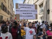 Anti-vaccine protester holds a placard during a rally in Paris, Saturday, July 17, 2021. Tens of thousands of people protested across France on Saturday against the government's latest measures to curb rising COVID-19 infections and drive up vaccinations in the country.