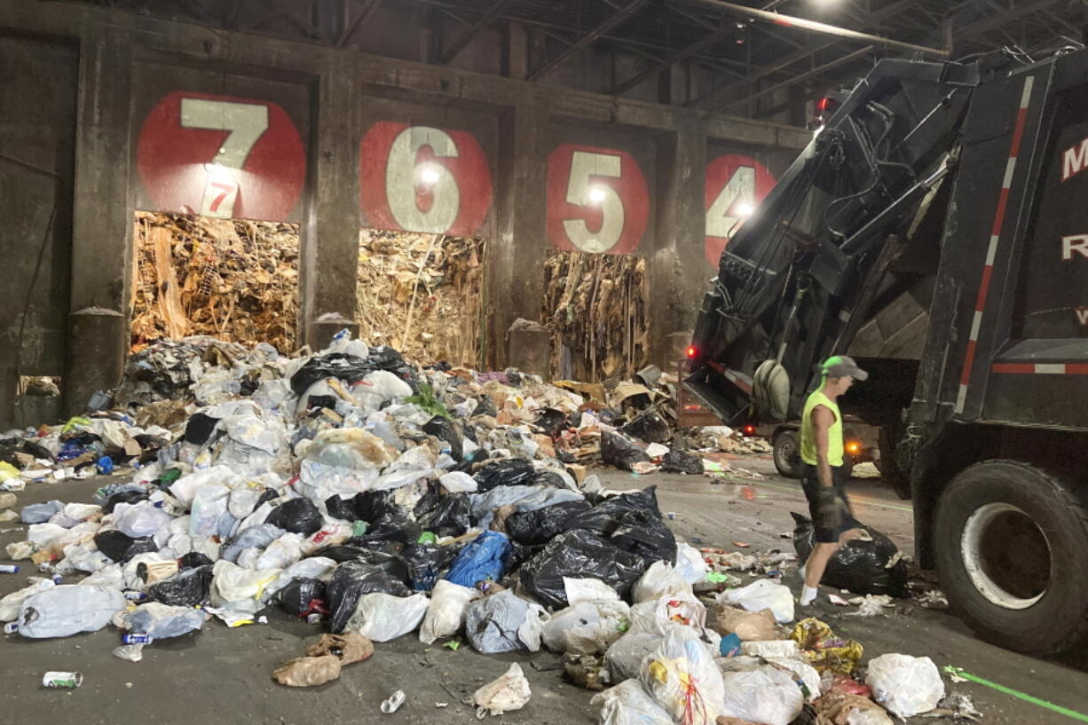 A worker unloads a garbage truck  June 22 at ecomaine in Portland, Maine. Waste-to-energy converters like ecomaine are seeing an uptick in the amount of trash they collect to produce power.