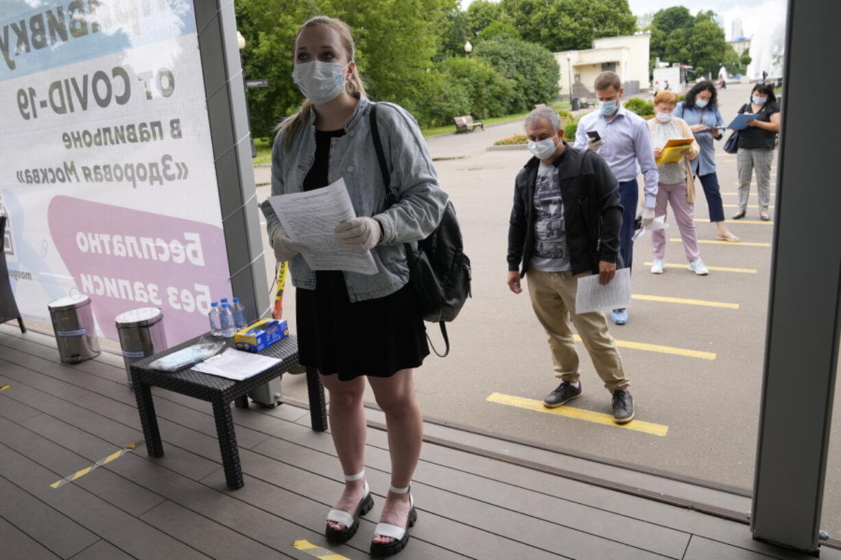 A group of people some of them wearing face masks to protect against coronavirus stand in line to get a coronavirus vaccine at a vaccination point in Gorky Park in Moscow, Russia, Wednesday, June 30, 2021. Russia was among the first in the world to announce and deploy a coronavirus vaccine last year, but so far only about 23 million, just over 15% of the population have received at least one vaccine shot. Hampered by widespread vaccine hesitancy and limited production capacity, Russia's vaccination rates have picked up in recent weeks, after authorities in many regions made shots mandatory for employees in certain sectors.