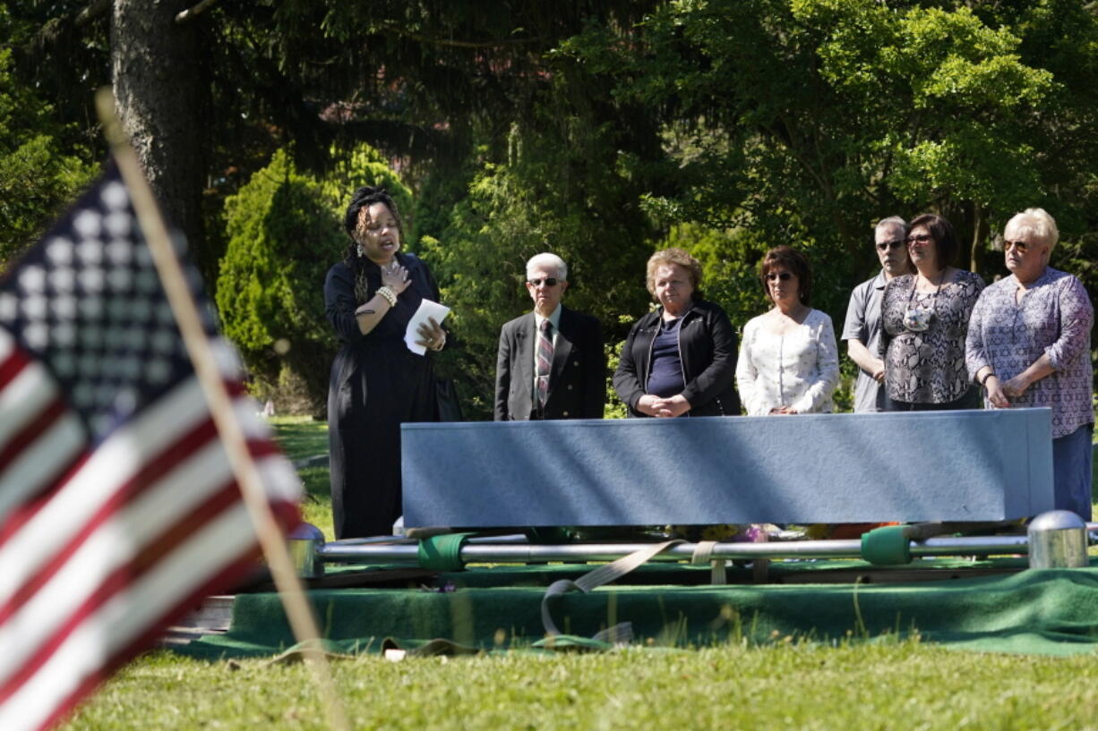 Edwina Frances Martin, Staten Island's public administrator of estates, left, says a few words during a burial of four people at a cemetery in the Staten Island borough of New York, Thursday, June 17, 2021. The deceased died during the coronavirus pandemic and were being stored at a temporary morgue in Brooklyn. The facility is out of sight and mind for many for many as the city celebrates its pandemic progress but stands as a reminder of the loss, upheaval and wrenching choices the virus inflicted in one of its deadliest U.S. hotspots.