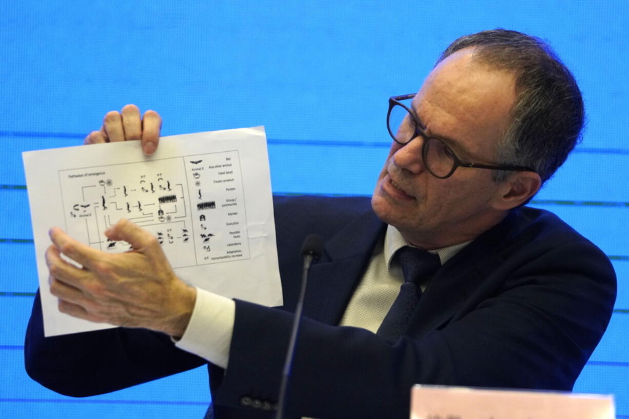 FILE - In this Feb. 9, 2021, file photo, Peter Ben Embarek of the World Health Organization team holds up a chart showing pathways of transmission of the virus during a joint news conference at the end of the WHO mission in Wuhan in central China's Hubei province. As the World Health Organization draws up plans for the next phase of its probe of how the coronavirus pandemic started, an increasing number of scientists say the U.N. agency it isn't up to the task and shouldn't be the one to investigate.