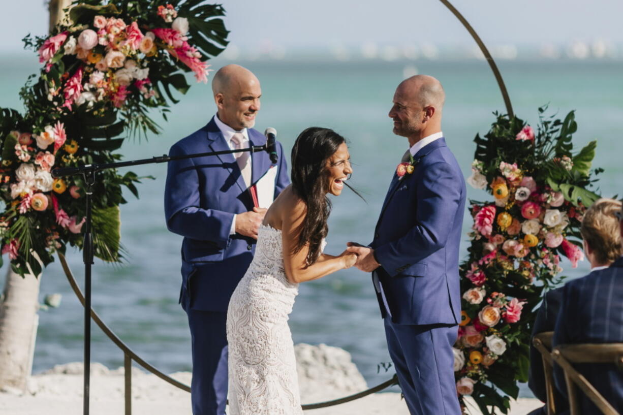 Associated Press sportswriter Larry Lage, left, officiates the wedding of Ryan Rutledge and Natalie LaRocca at the Postcard Inn Beach Resort and Marina in Islamorada, Fla., on March 27.