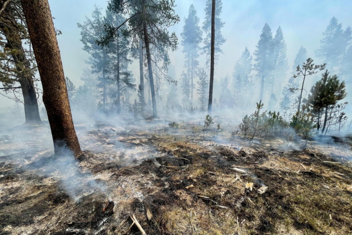 In this photo provided by the Bootleg Fire Incident Command, the Bootleg Fire is seen smoldering in southern Oregon, Saturday, July 17, 2021. The destructive Bootleg Fire, one of the largest in modern Oregon history, has already burned more than 476 square miles (1,210 square kilometers), an area about the size of Los Angeles. Meteorologists predicted critically dangerous fire weather through at least Monday with lightning possible in both California and southern Oregon.