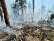 In this photo provided by the Bootleg Fire Incident Command, the Bootleg Fire is seen smoldering in southern Oregon, Saturday, July 17, 2021. The destructive Bootleg Fire, one of the largest in modern Oregon history, has already burned more than 476 square miles (1,210 square kilometers), an area about the size of Los Angeles. Meteorologists predicted critically dangerous fire weather through at least Monday with lightning possible in both California and southern Oregon.